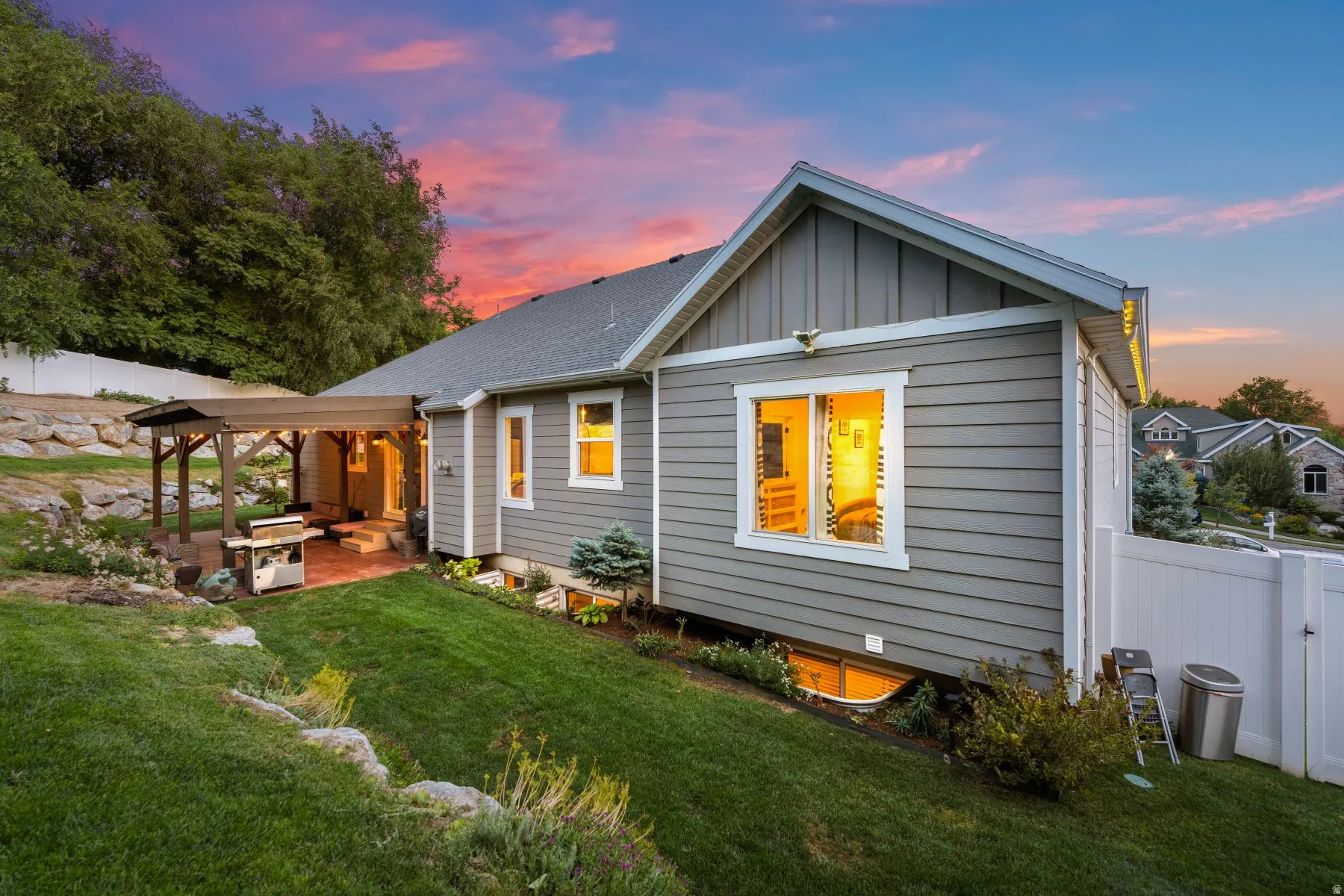 Rear view of house with board and batten siding, a patio, and roof with shingles