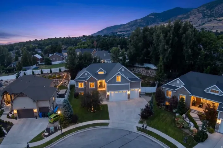 Modern traditional residence with a two-car garage, stone and siding exterior, and landscaped front yard with mature plantings