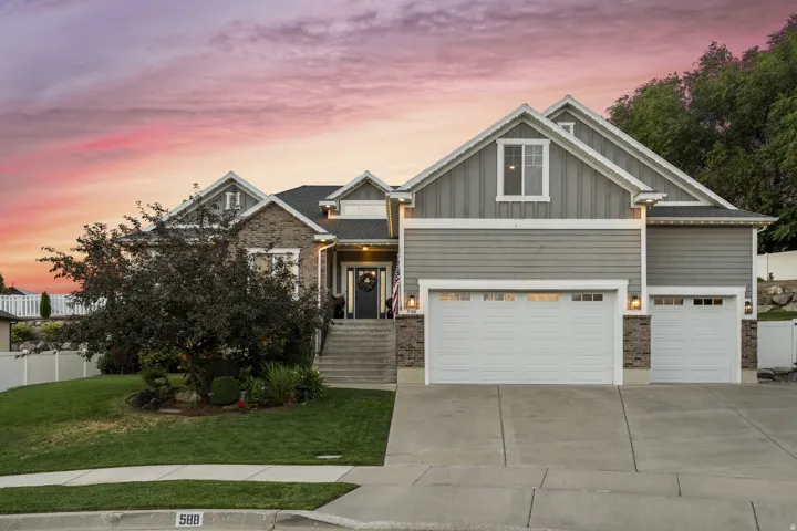 Craftsman house featuring board and batten siding, concrete driveway, brick siding, and an attached garage