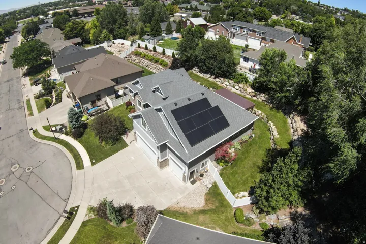 Two-story residence featuring a gray exterior siding and a multi-gabled roofline with solar panels
