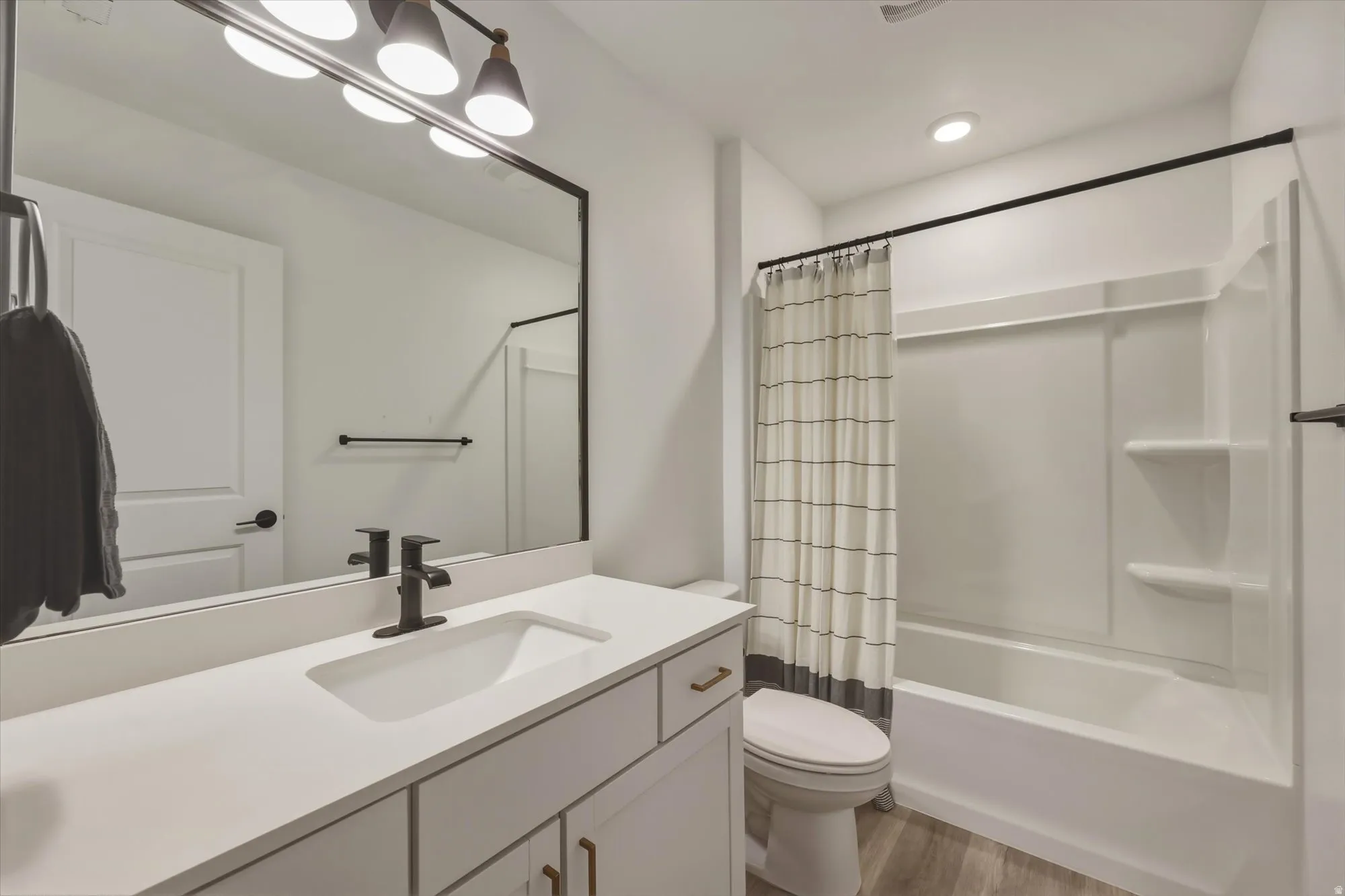 Bathroom featuring a single vanity with an integrated rectangular sink, matte black faucet, and white countertop