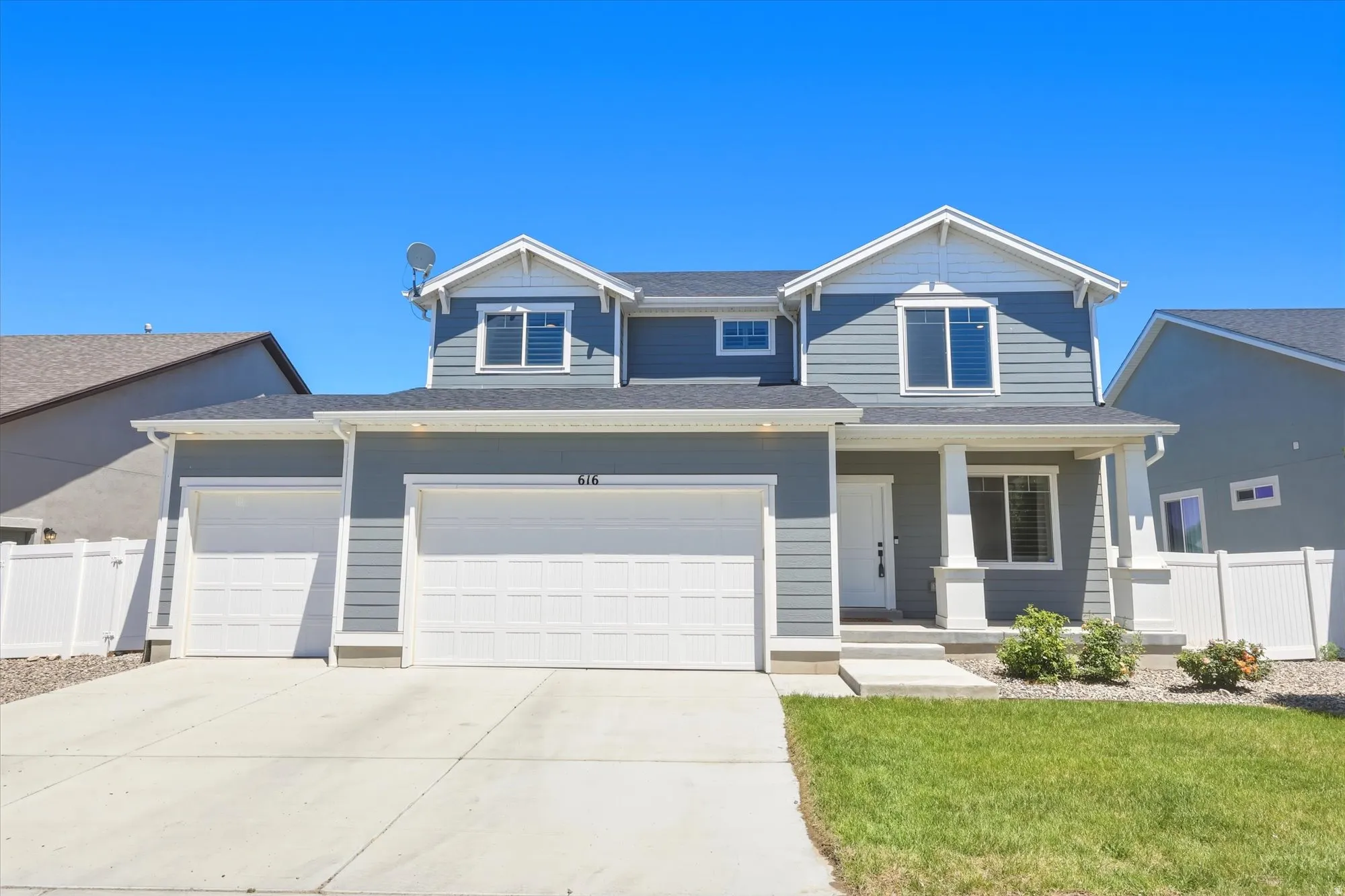 Two-story home with a light blue siding exterior, white trim, and a prominent covered porch