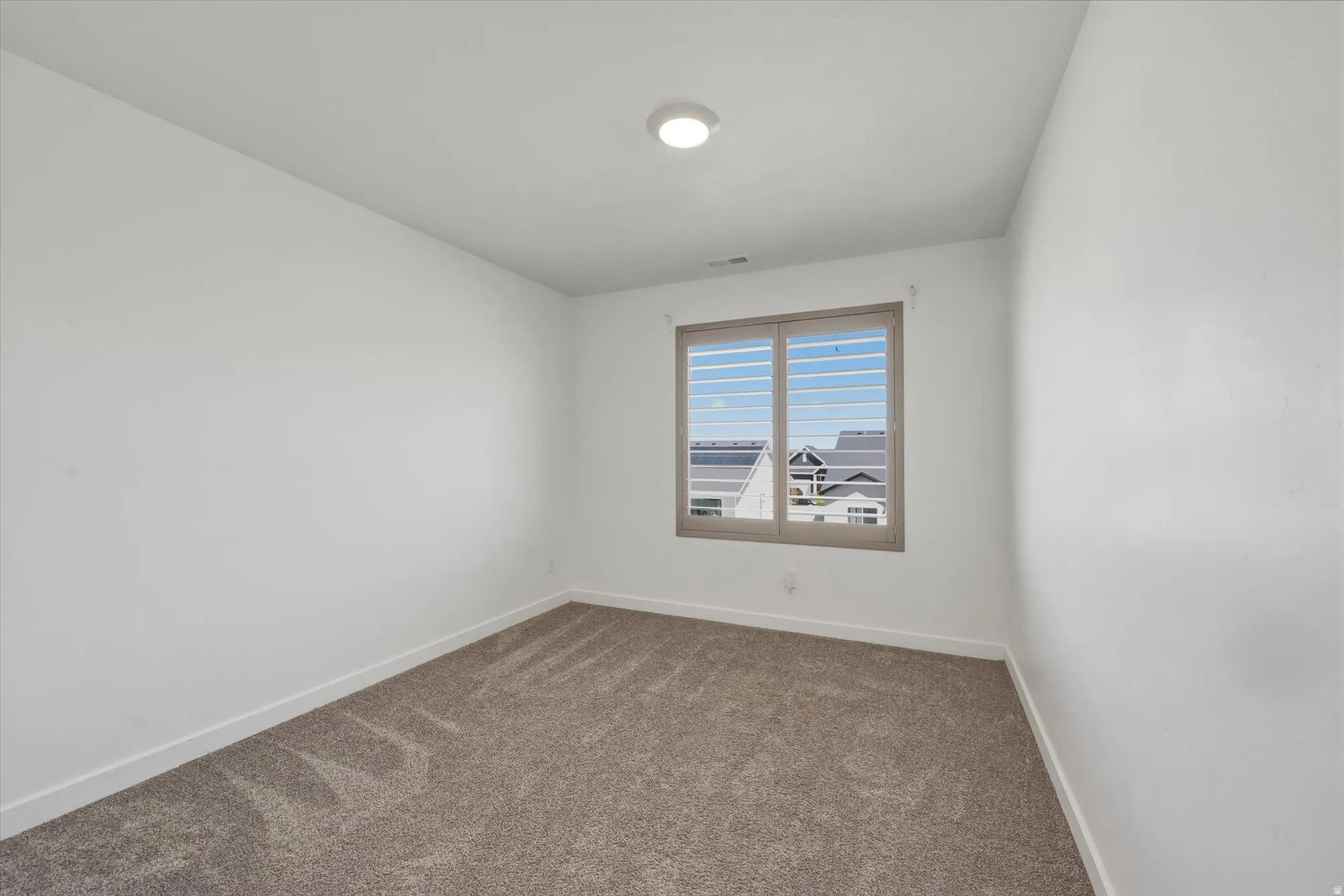 Room featuring neutral wall finishes and patterned carpet flooring