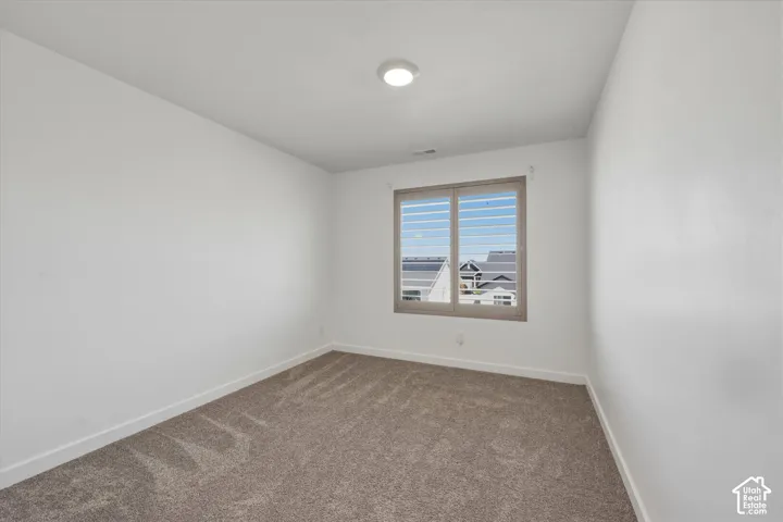 Room featuring neutral wall finishes and patterned carpet flooring