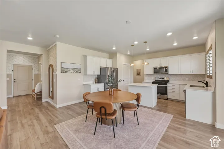 Open-concept living space featuring wood-finish flooring, recessed lighting, and a modern kitchen