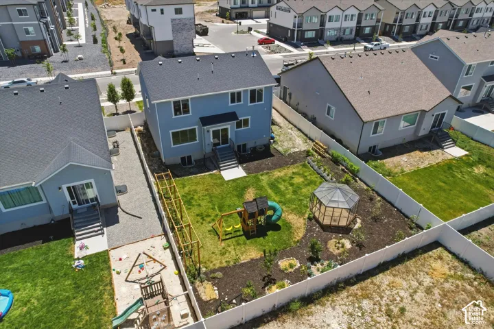 Expansive backyard featuring a manicured lawn, a white privacy fence, and a dedicated garden area with a greenhouse structure