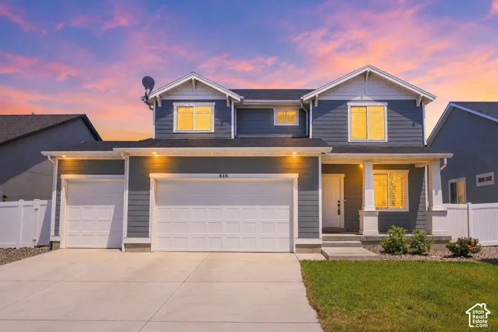 Two-story residence featuring a dark gray siding exterior with white trim accents and a white picket fence