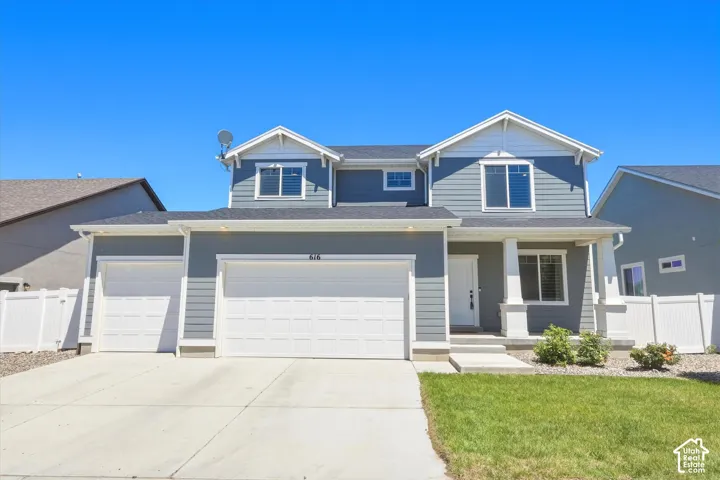 Two-story home with a light blue siding exterior, white trim, and a prominent covered porch