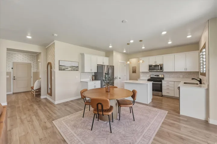 Open-concept living space featuring wood-finish flooring, recessed lighting, and a modern kitchen
