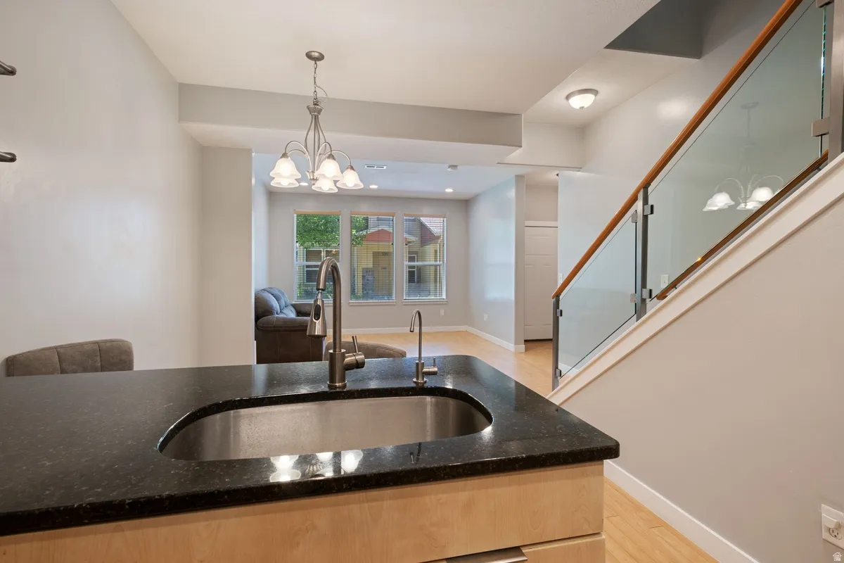 Kitchen island featuring a stainless steel undermount sink and a dark countertop