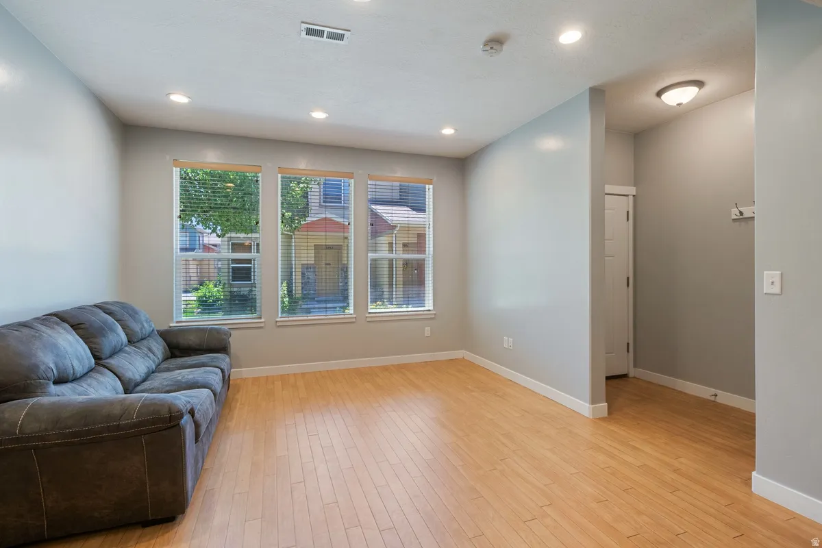 Spacious interior featuring wood-finish flooring, light gray walls, and recessed ceiling lighting