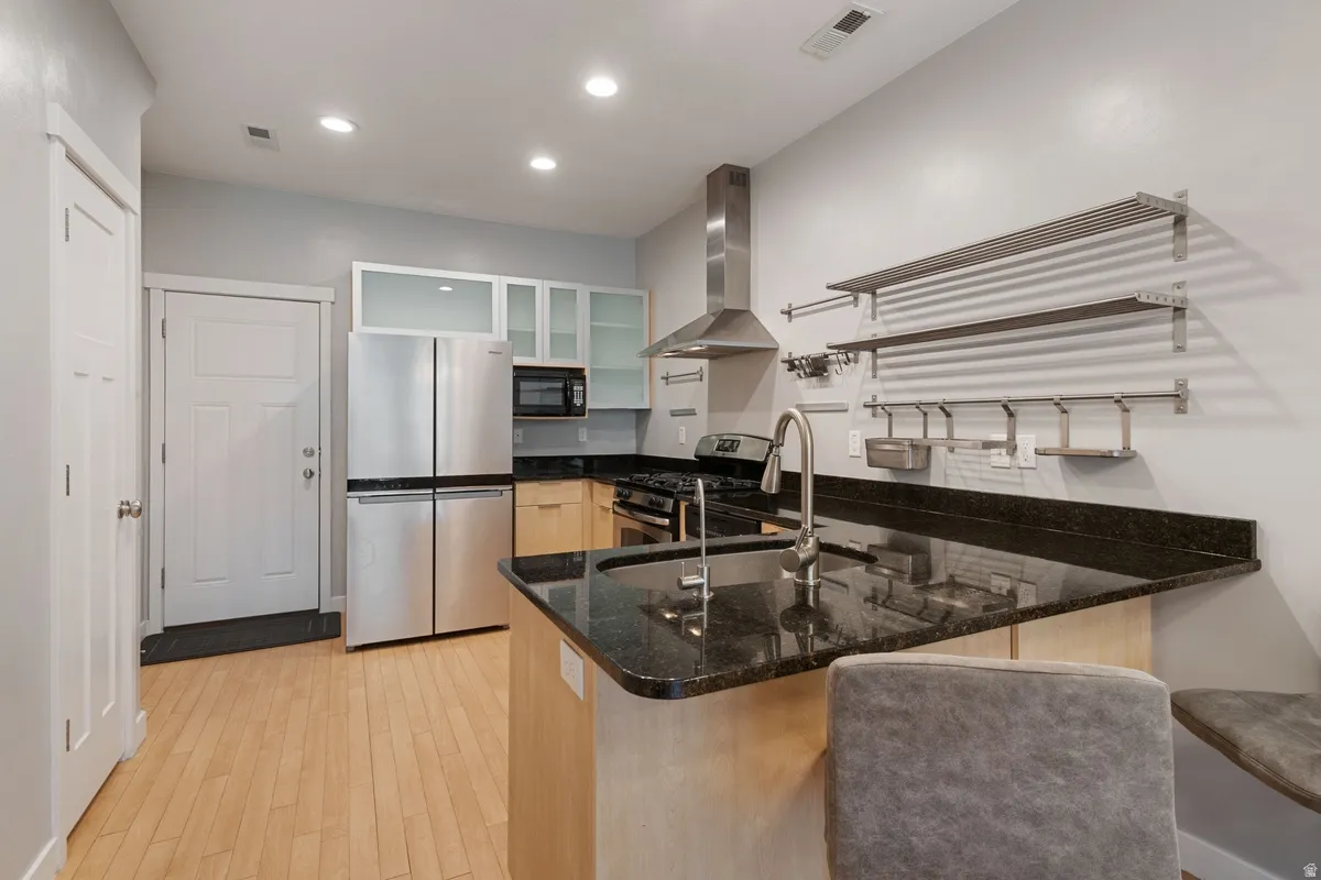 Kitchen featuring wood-finish flooring and dark countertops