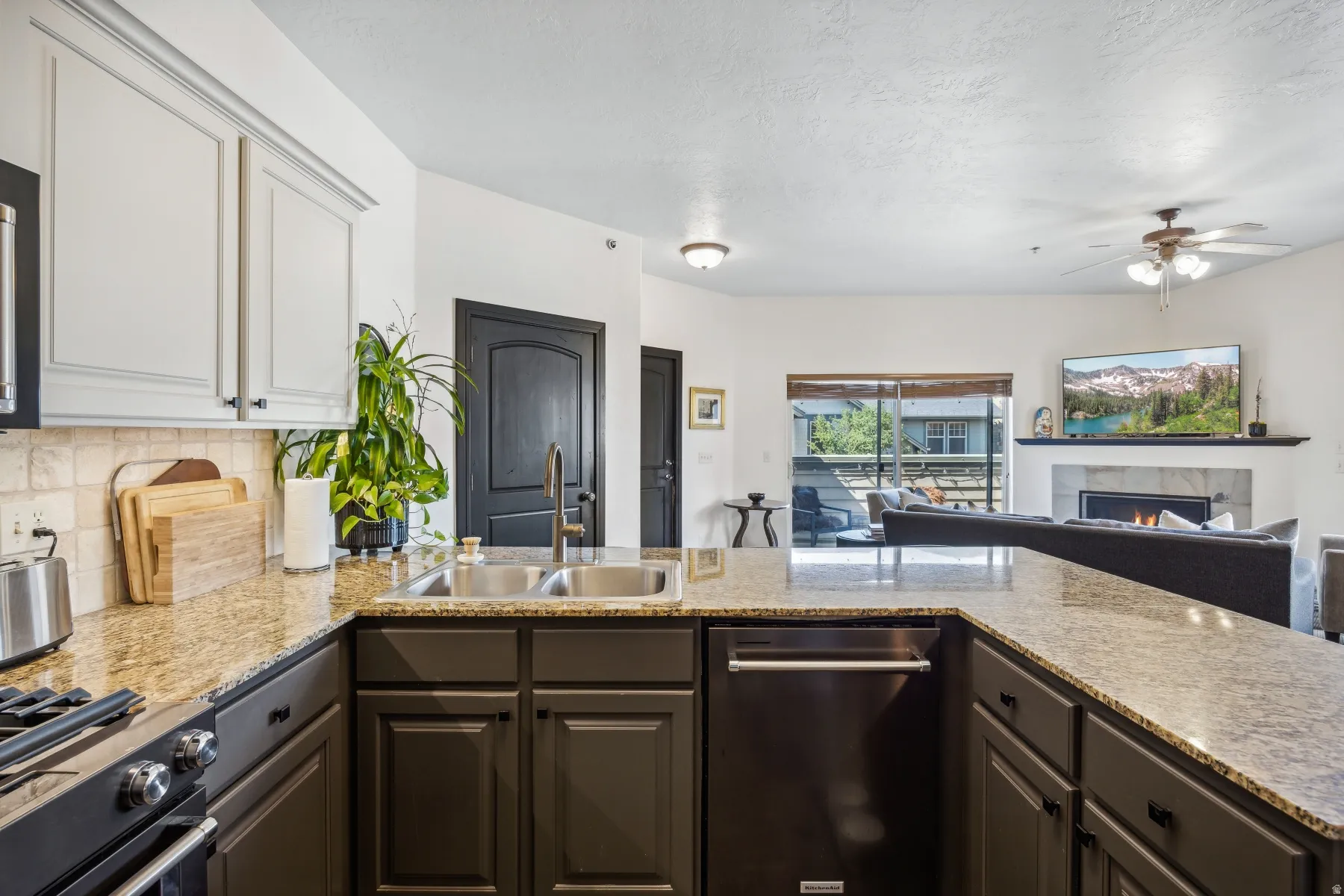 Kitchen island with a double basin sink, bronze faucet, and granite countertops