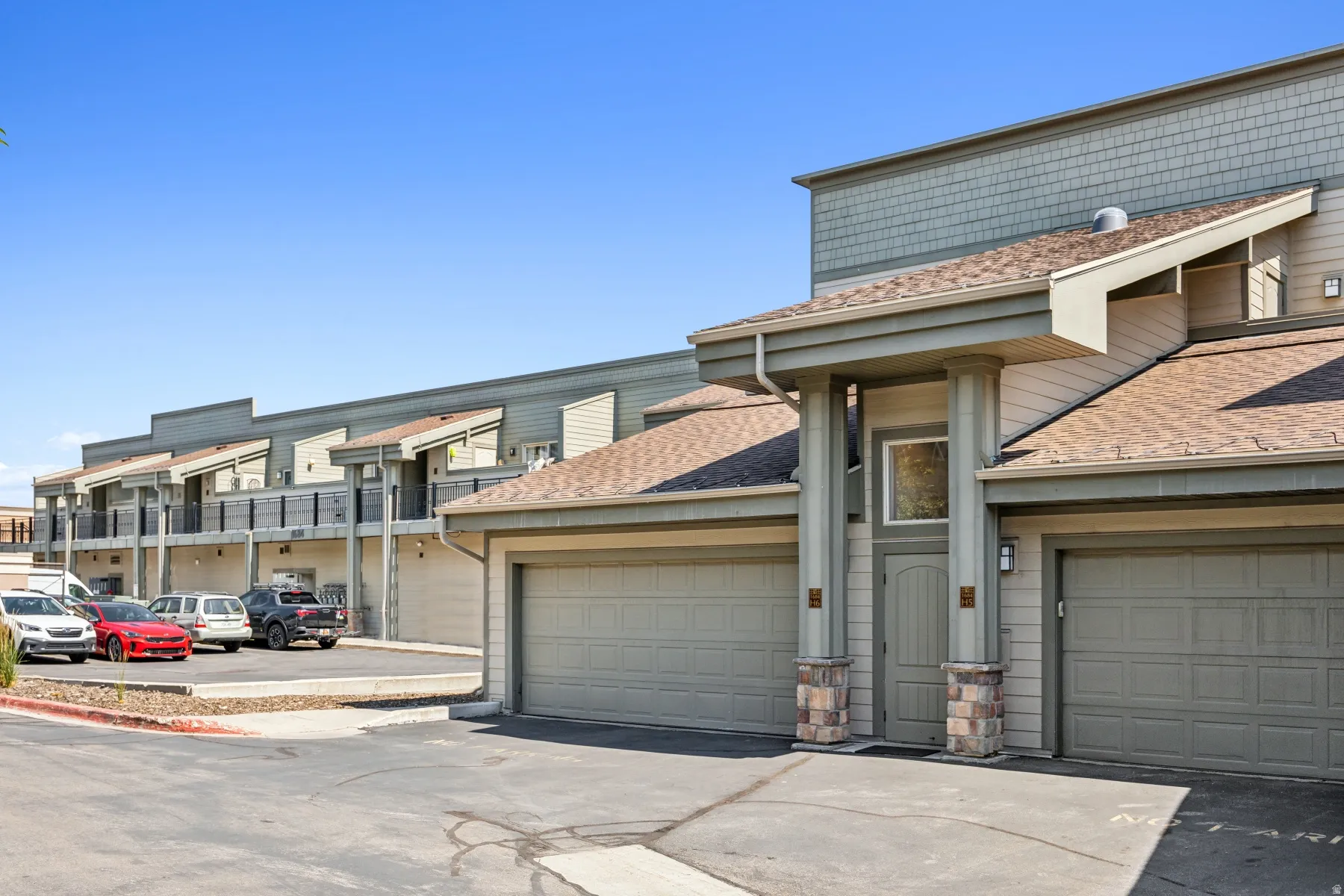 Multi-level residential building featuring durable siding, integrated garages, stone veneer accents, and a covered entryway