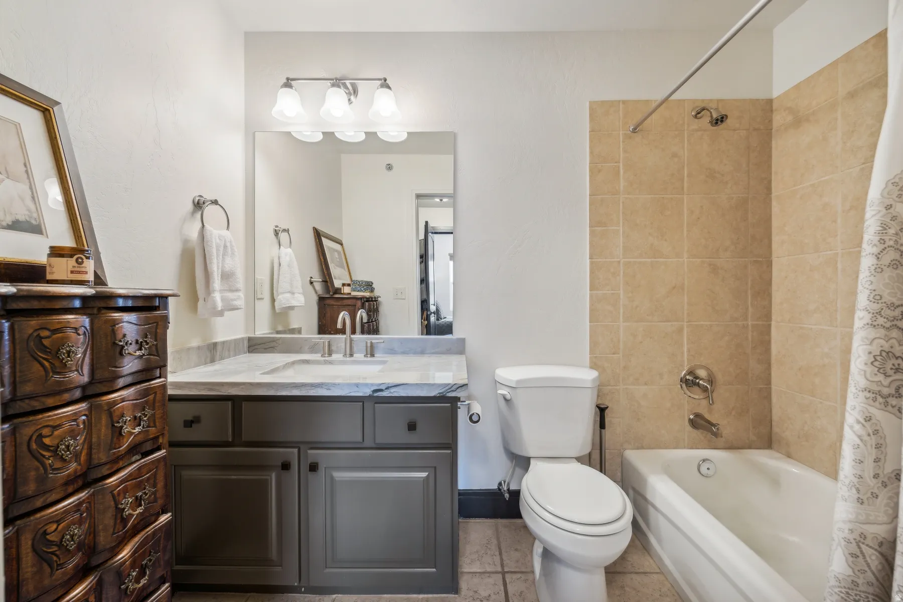 Bathroom featuring a vanity with a light-colored countertop, an undermount sink, and a large mirror