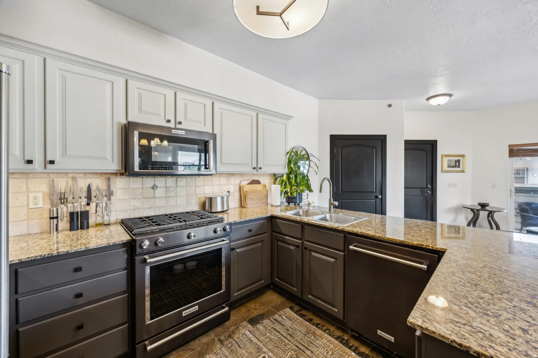 Kitchen featuring two-tone cabinetry, granite countertops, and stainless steel appliances