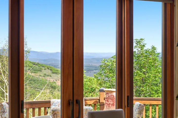 Expansive glass doors showcasing mountain and tree-lined vistas