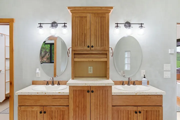 Bathroom featuring a double vanity with wood-finish cabinetry and light-toned countertops