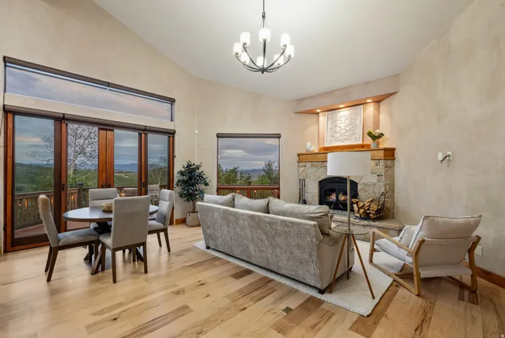 Spacious interior featuring wood-finish flooring, vaulted ceilings, and an exposed stone fireplace