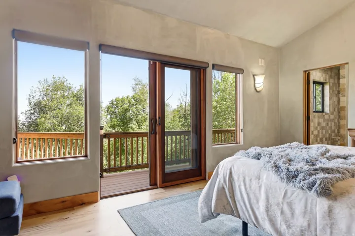 Hardwood flooring throughout featuring a private balcony with wood railing