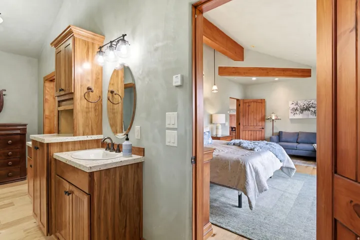 Bathroom vanity with a white oval sink, speckled countertop, and wood-finish cabinetry