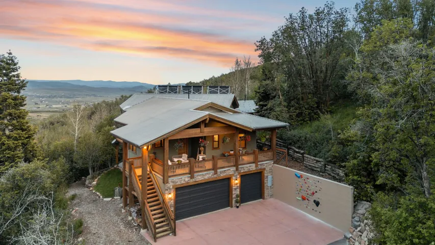 Two-story mountain-style residence featuring a metal roof and stone accents