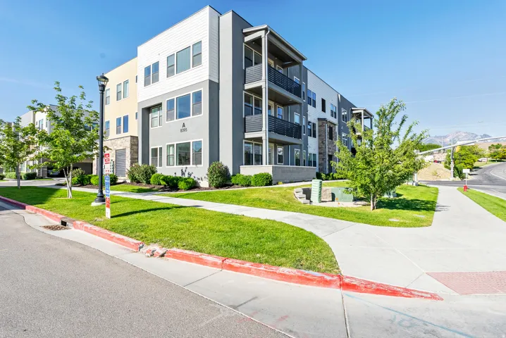 Contemporary multi-story building featuring varied facade materials including horizontal siding, stucco, and stone accents
