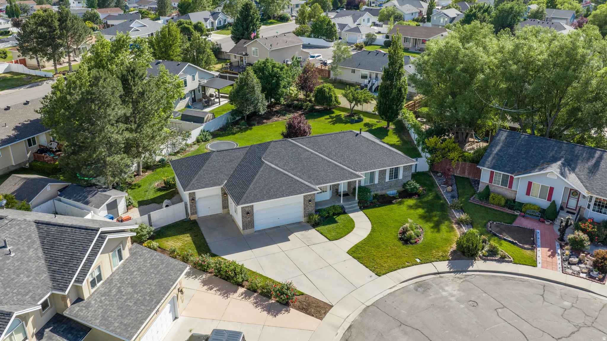 Single-story residence featuring a dark shingle roof and a concrete driveway