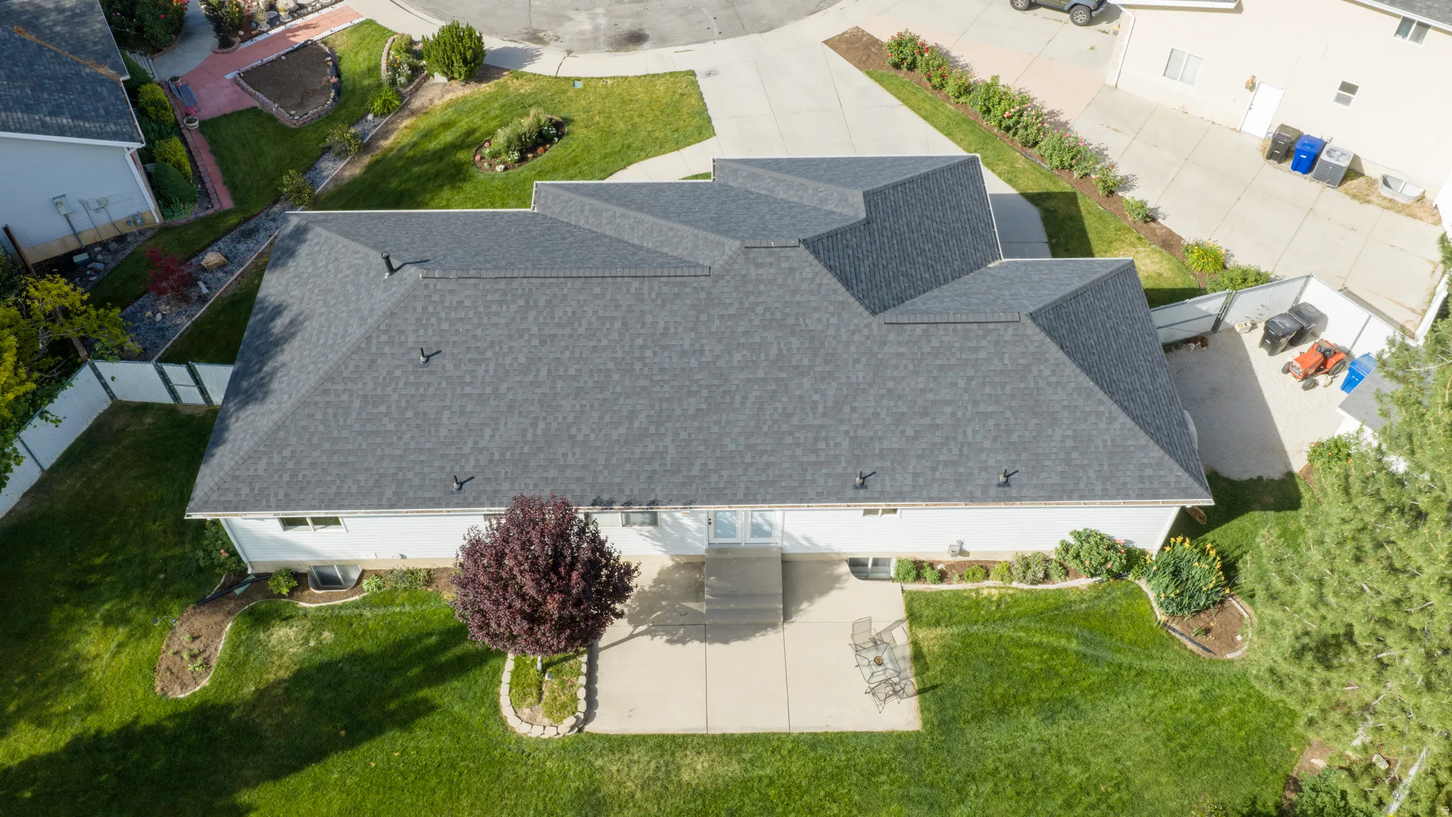 Aerial perspective showcasing a sprawling property with a multi-pitched dark gray shingle roof