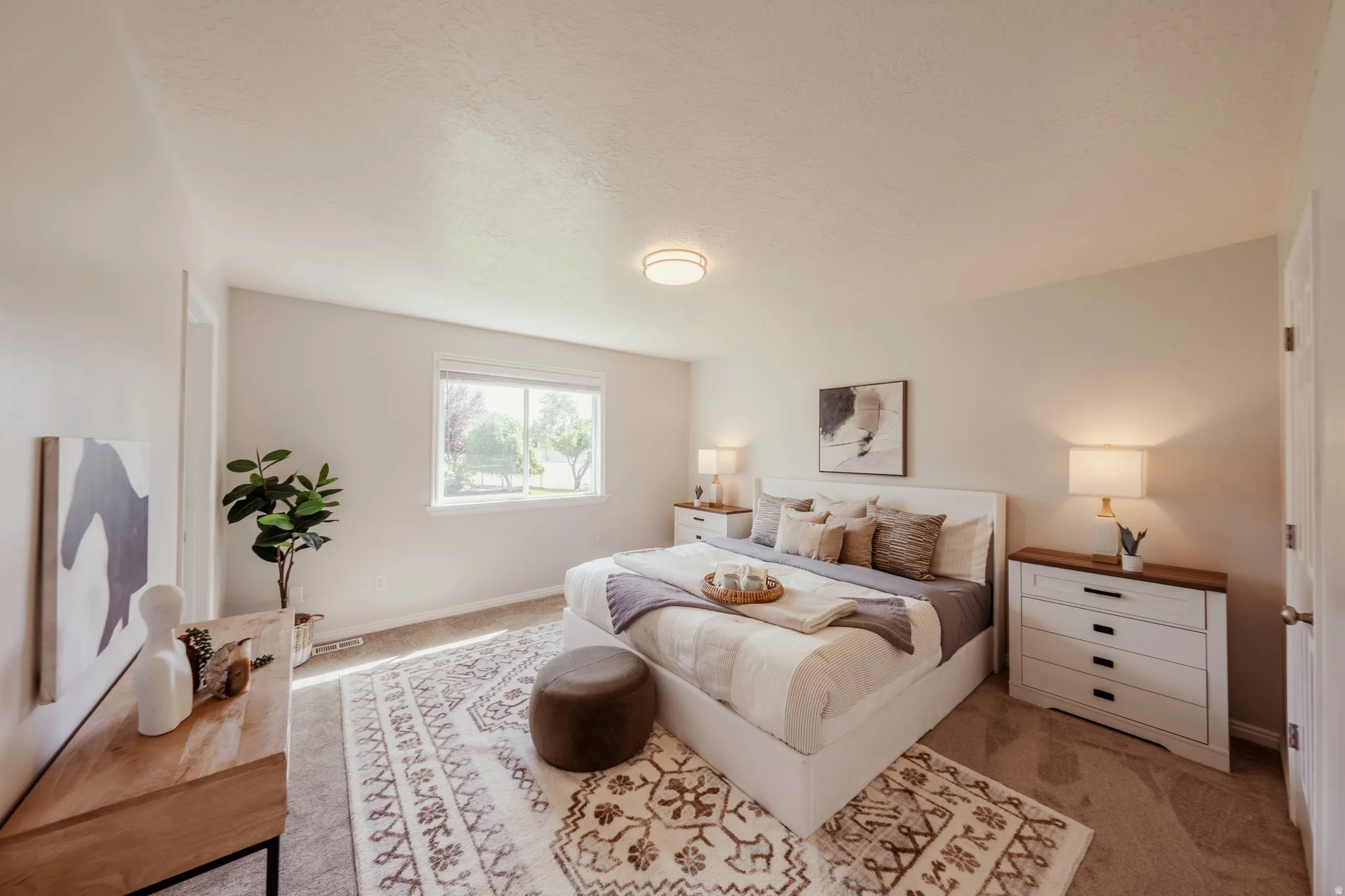 Spacious room with a neutral color palette, featuring a window, carpet flooring, a ceiling-mounted light fixture, and an entry door