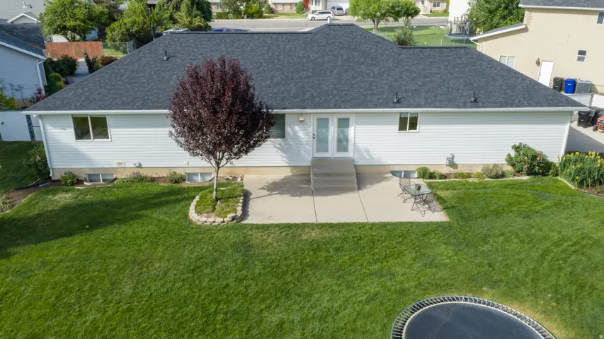 Rear exterior with white vinyl siding and a dark shingle roof