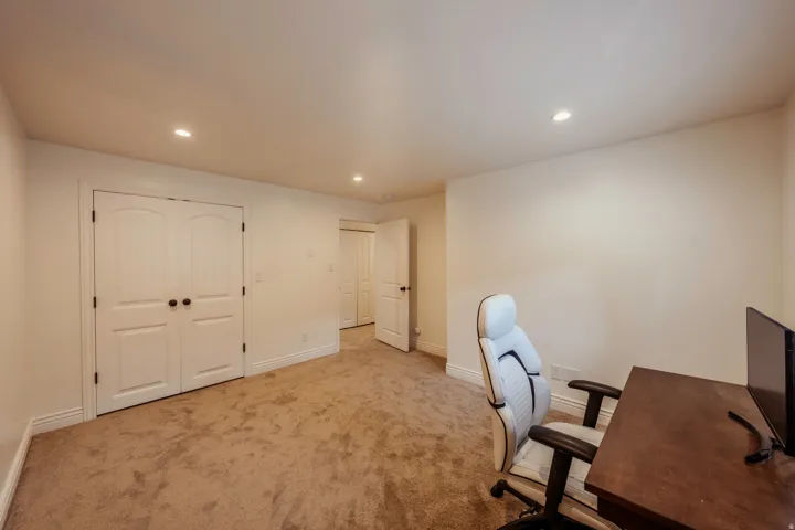 Spacious room featuring neutral carpet flooring, recessed lighting, white trim, and two sets of white paneled double doors