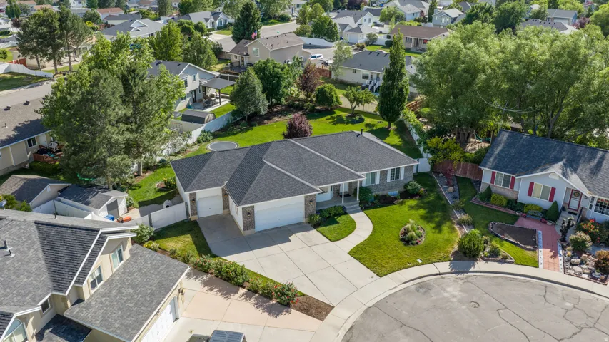 Single-story residence featuring a dark shingle roof and a concrete driveway