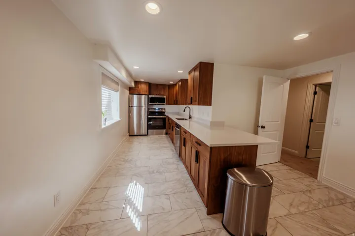 Kitchen featuring wood-finish cabinetry, white countertops, and stainless steel appliances
