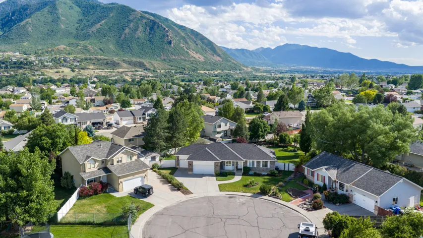 Residential cul-de-sac setting featuring a variety of single-family homes with pitched roofs, surrounded by mature trees and mountain scenery