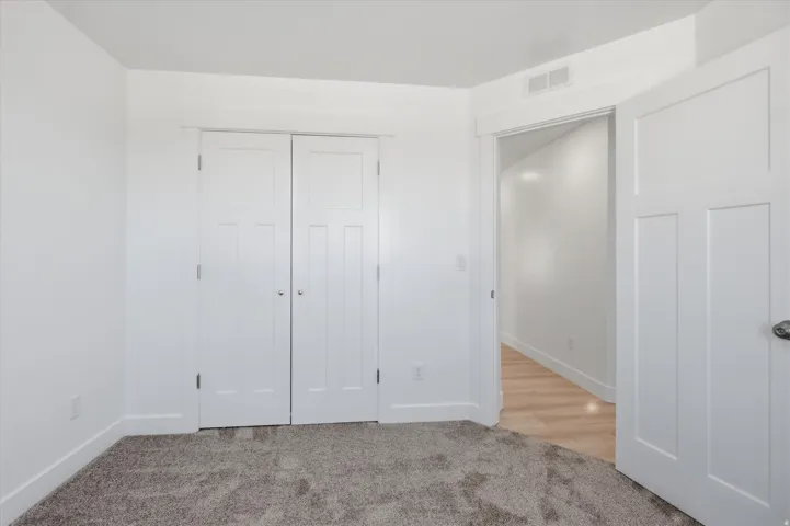 Neutral interior space with light gray carpet and white walls
