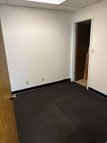Interior space featuring white walls and dark flooring