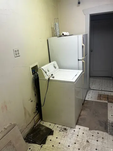 Utility area featuring a top-load washing machine and a two-door refrigerator