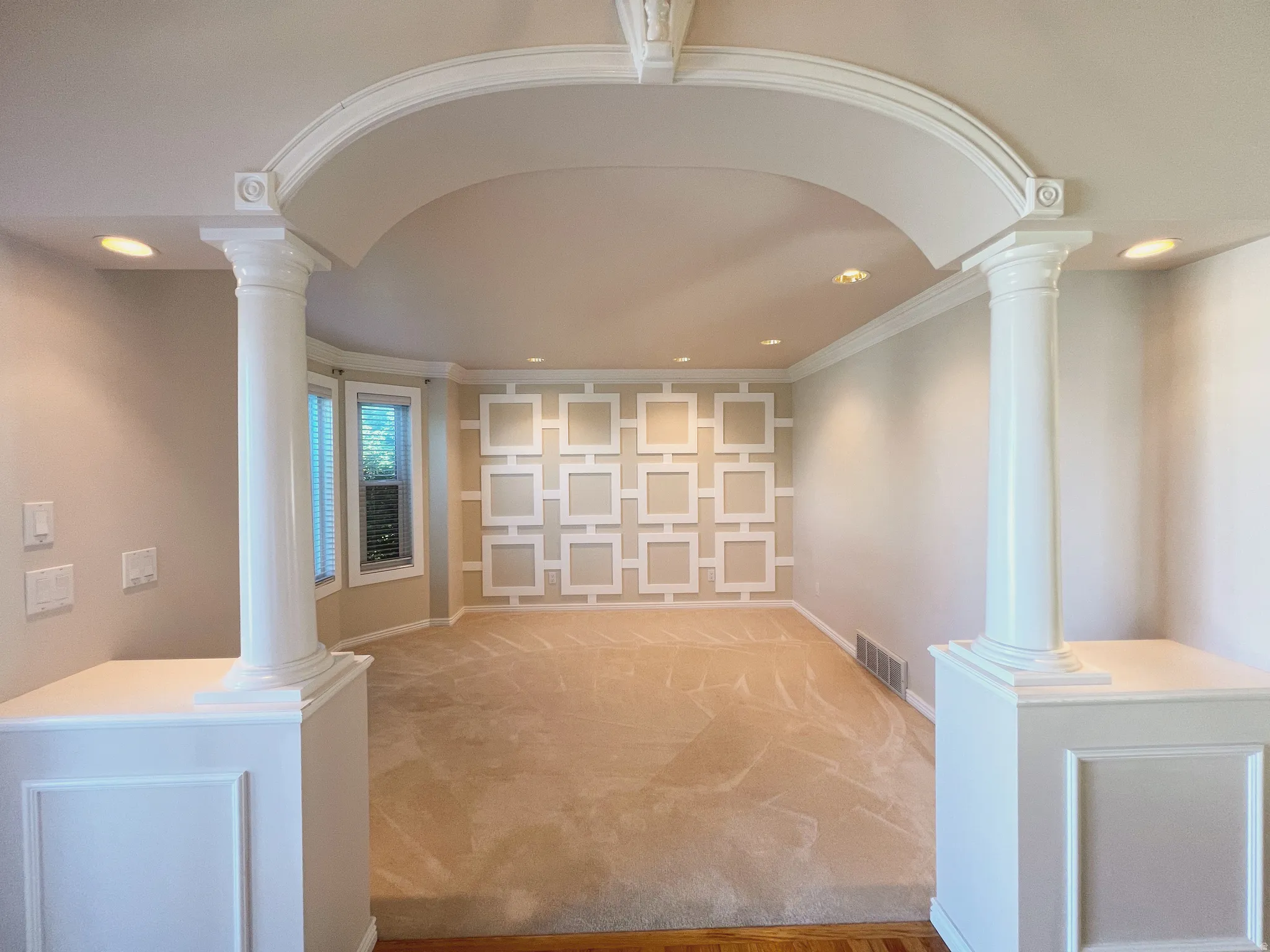 Archway entry featuring classic columns and decorative trim