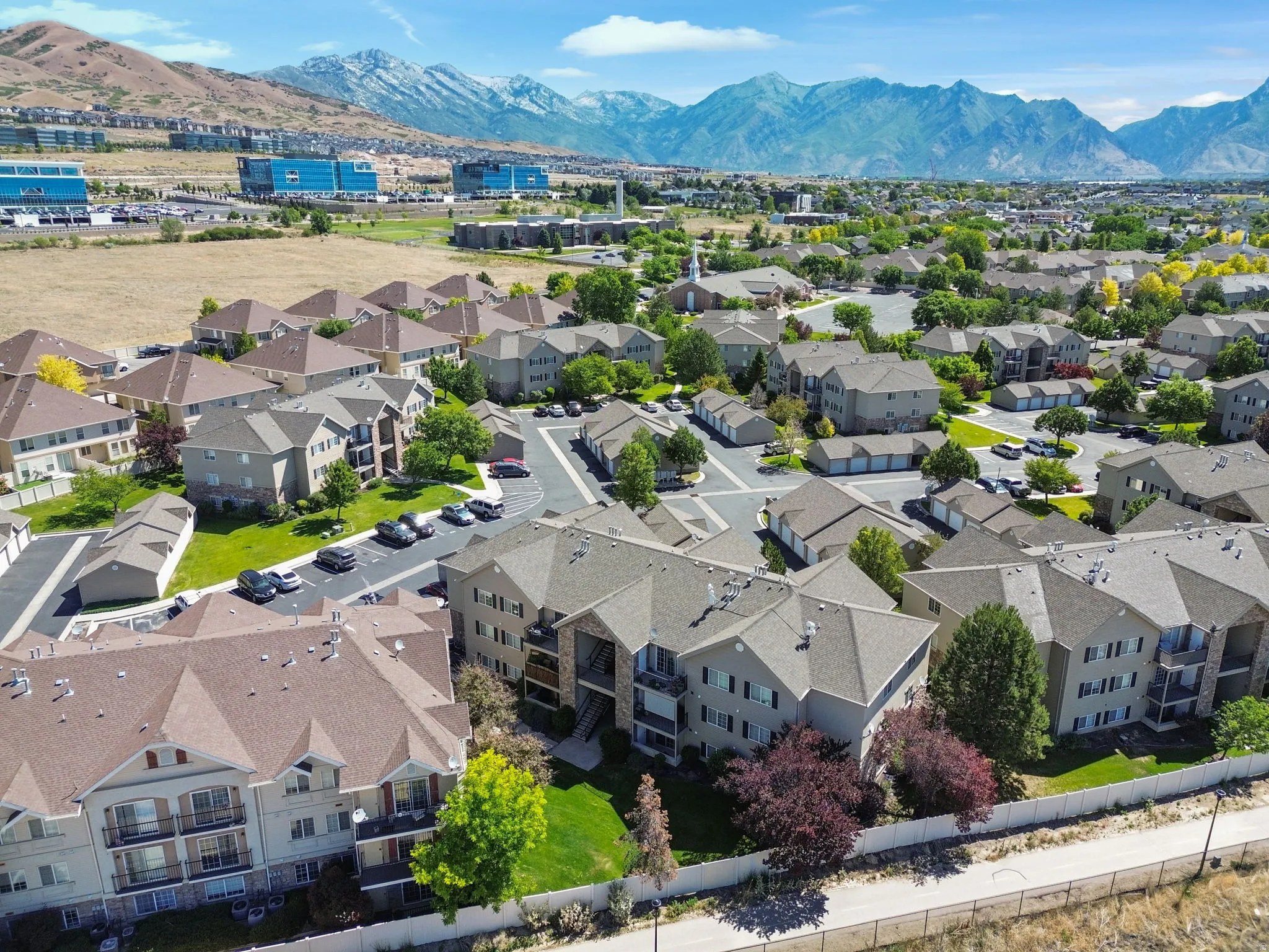 Aerial perspective showcasing a residential community with multi-story buildings, pitched roofs, and individual balconies