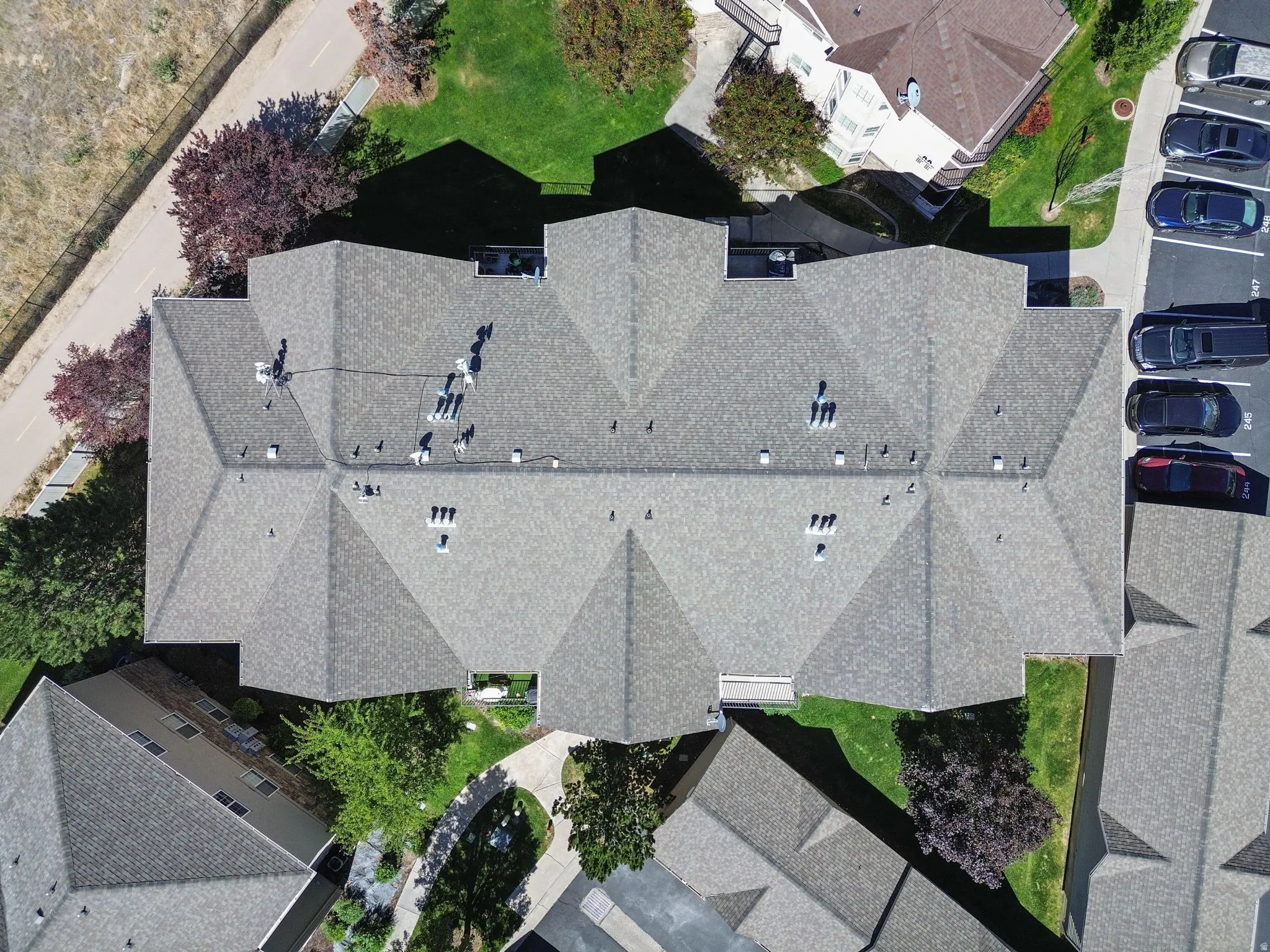 Gable roofline featuring dimensional shingles, multiple skylights, and integrated ventilation systems
