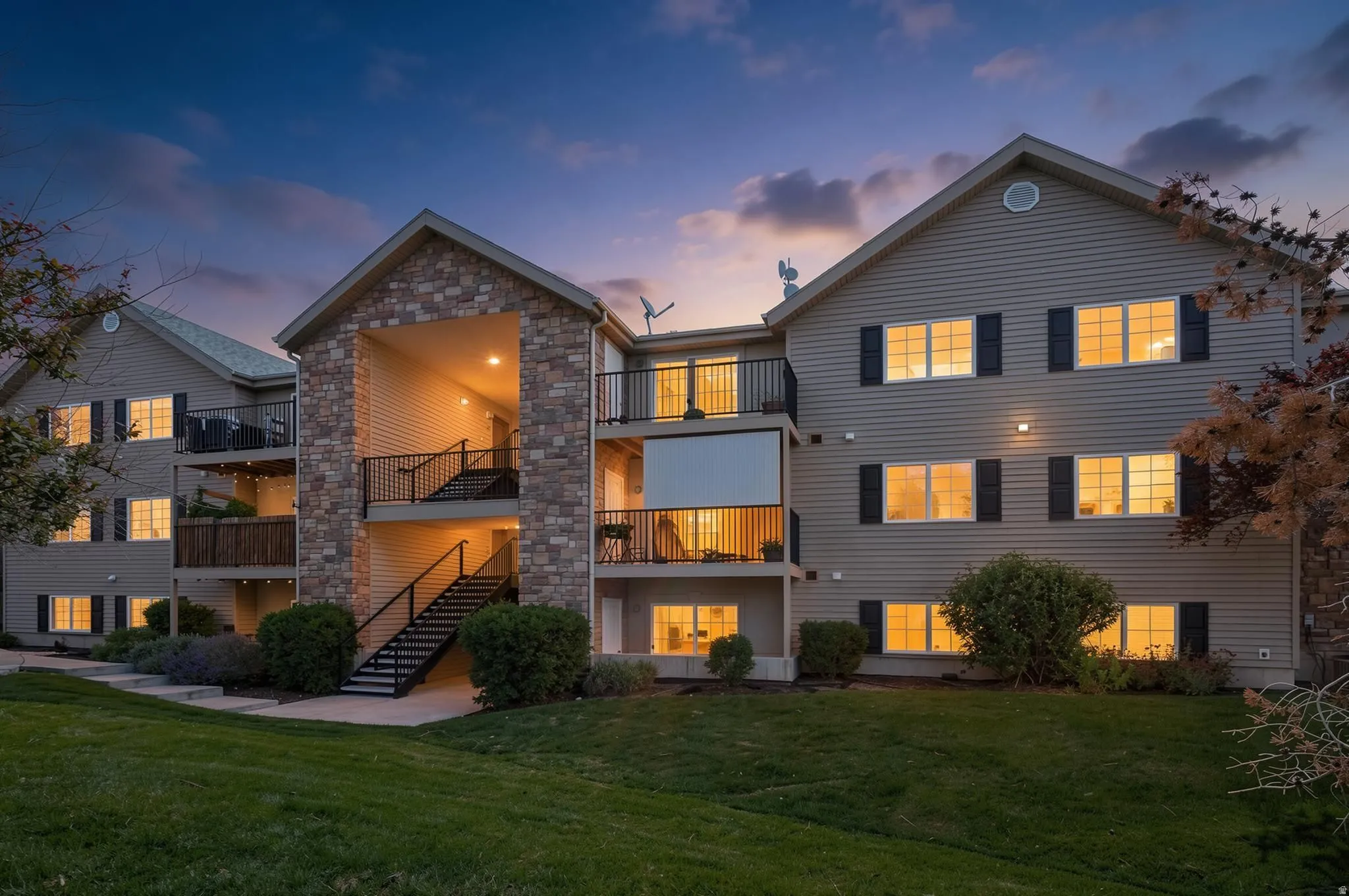 Multi-story residential building featuring stone veneer and horizontal siding