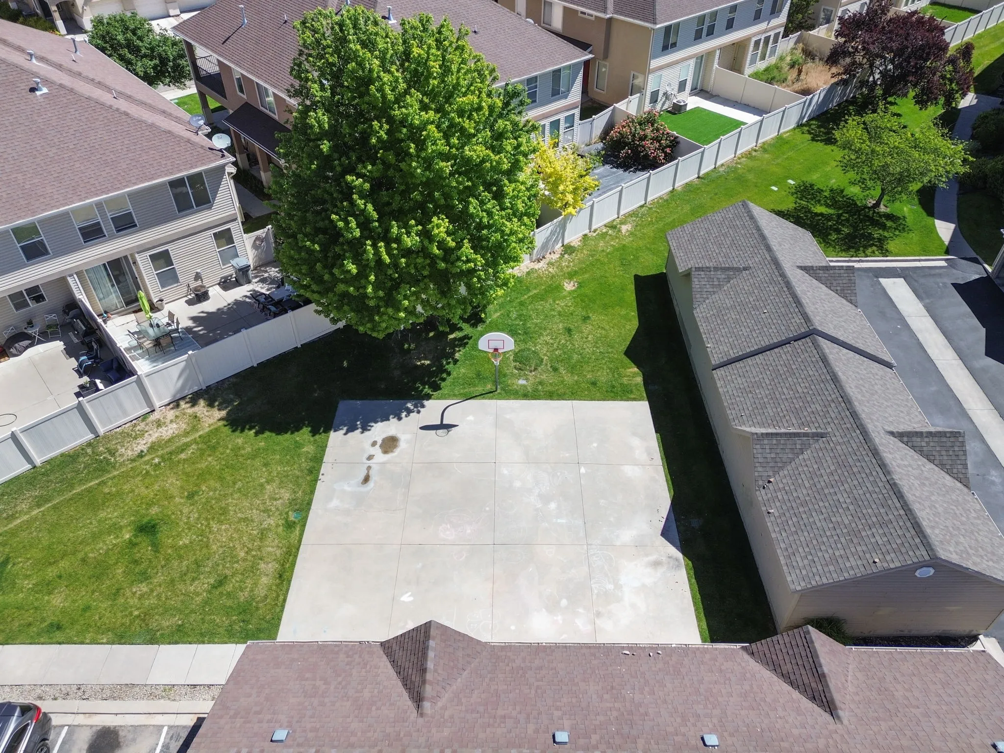 Expansive concrete pad suitable for recreation, surrounded by manicured green lawn