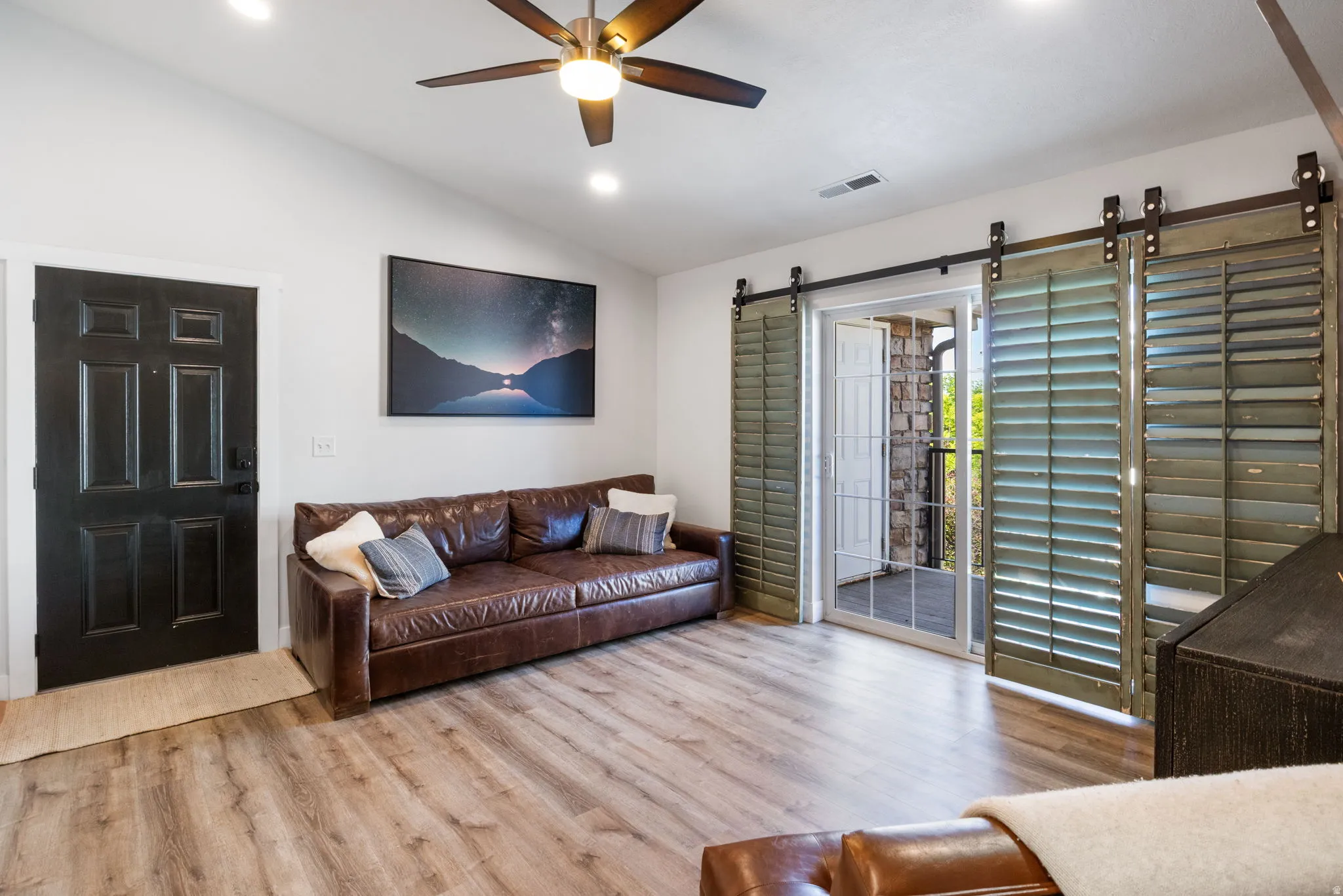 Living area featuring wood-finish flooring, a vaulted ceiling, and recessed lighting