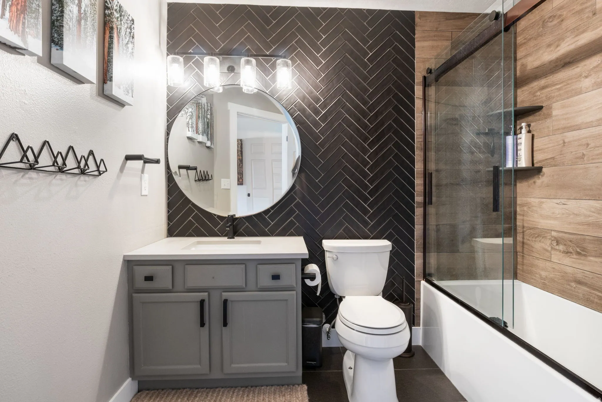 Bathroom featuring a vanity with a light gray cabinet, white countertop, and a circular mirror