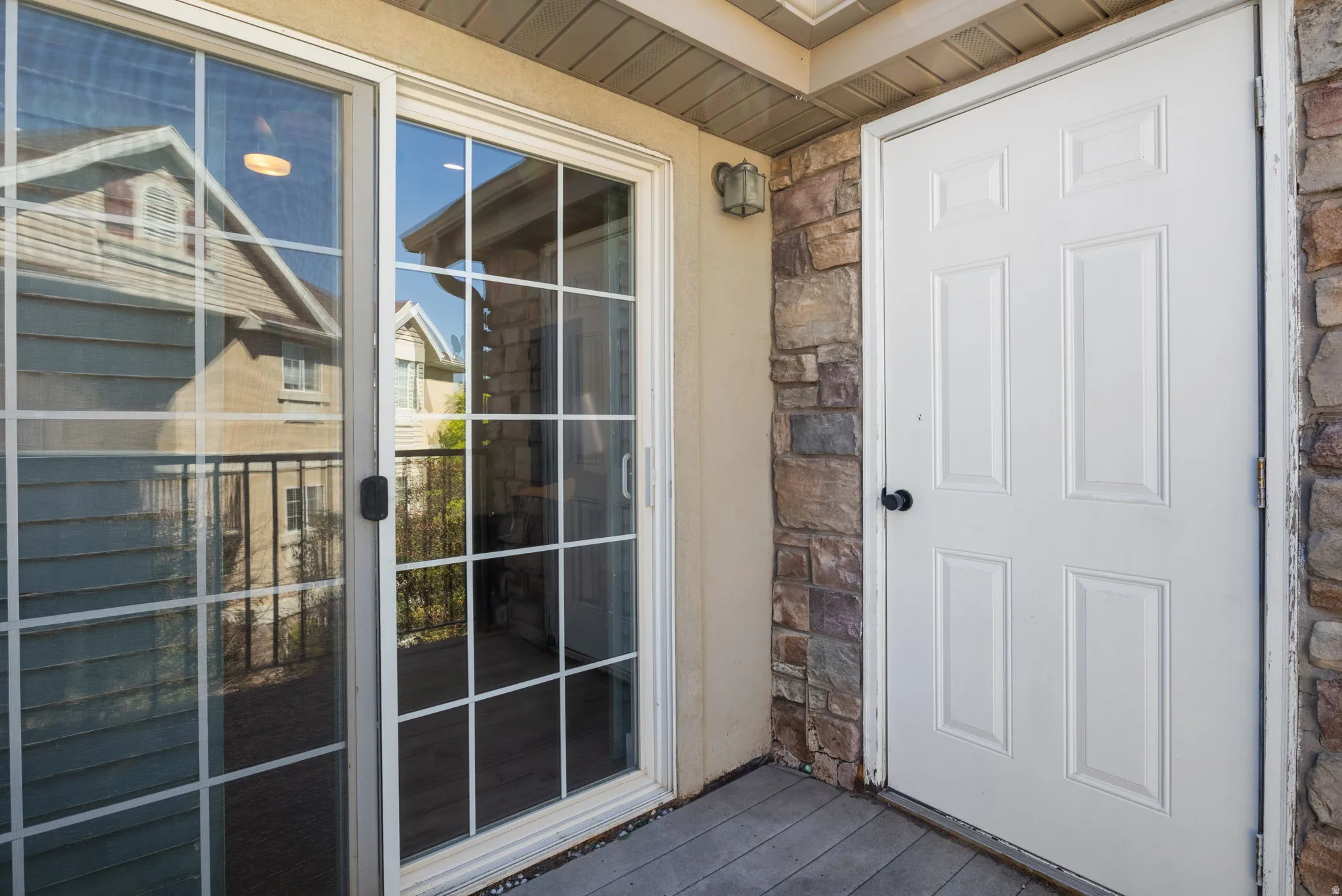 Entryway featuring a white panel door and a sliding glass door with grid-patterned panes