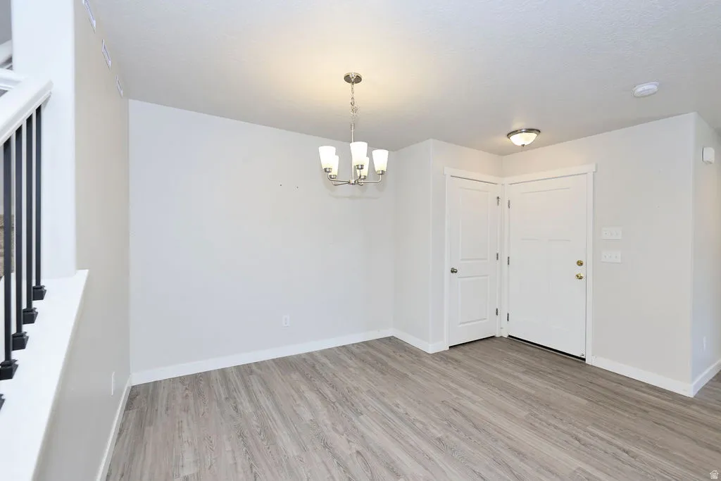 Open concept living space featuring wood-finish flooring, a modern chandelier, and recessed lighting