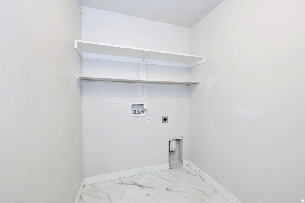 Utility room with white walls, two white shelving units, and marble-finish tile flooring