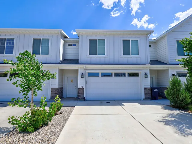 Contemporary multi-story facade featuring white vertical siding and horizontal accent siding