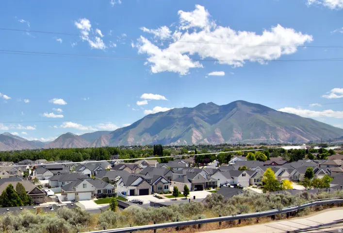 Expansive mountain scenery with a residential development featuring single-family homes with pitched roofs and attached garages